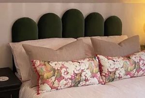 Bed with green headboard and pink and floral duvet set